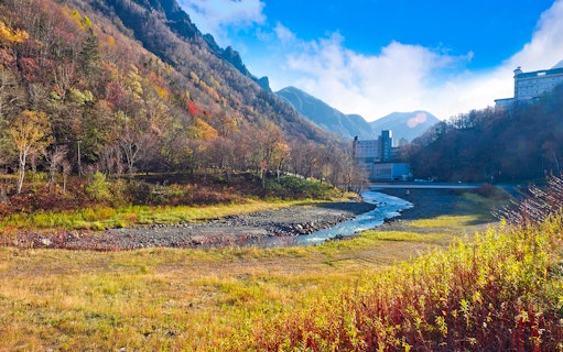 Hokkaido mountain landscape with autumn foliage and a river near Sapporo.