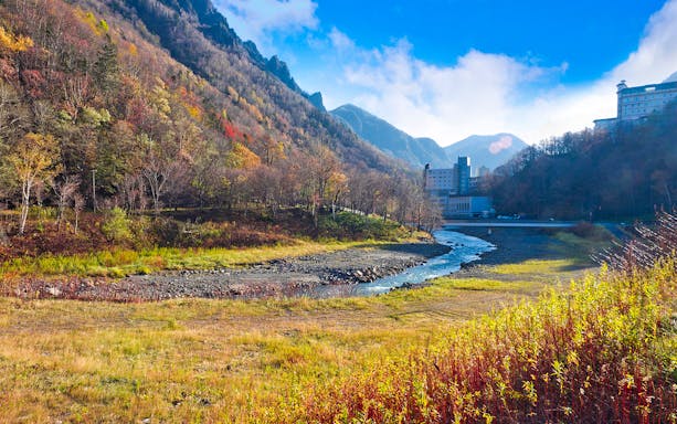 Hokkaido mountain landscape with autumn foliage and a river near Sapporo.