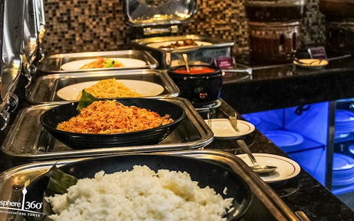 Buffet spread with rice, noodles, and dishes at Atmosphere 360 Revolving Restaurant.