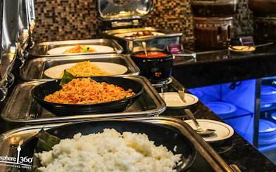 Buffet spread at Atmosphere 360 Revolving Restaurant, featuring rice and noodles.