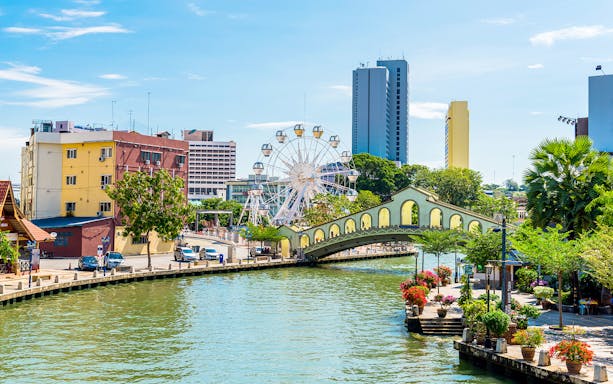 Melaka River with bridge and Ferris wheel in the background, Malaysia.