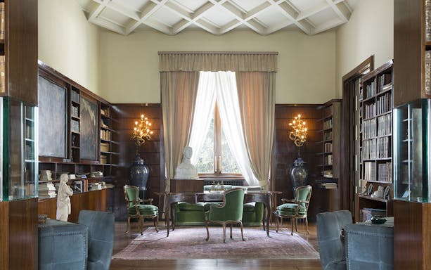 Villa Necchi Campiglio library with elegant furnishings and large window.
