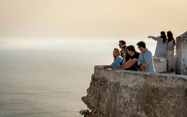 Group enjoying ocean view from a cliff in Nazaré on a tour from Lisbon.