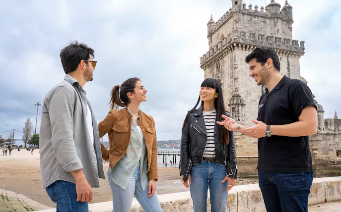 Group of people enjoying a conversation near Belém Tower, Lisbon, during a 360º SkyWalk tour.