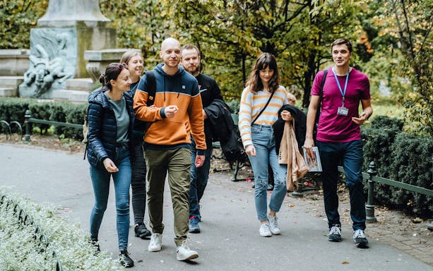 Group walking with a guide on a Traditional Polish Food Tour in a park.