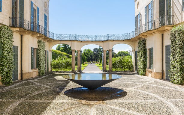 Villa e Collezione Panza courtyard with modern art installation and garden view.