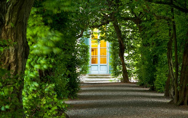 Pathway leading to Villa e Collezione Panza entrance surrounded by lush greenery.