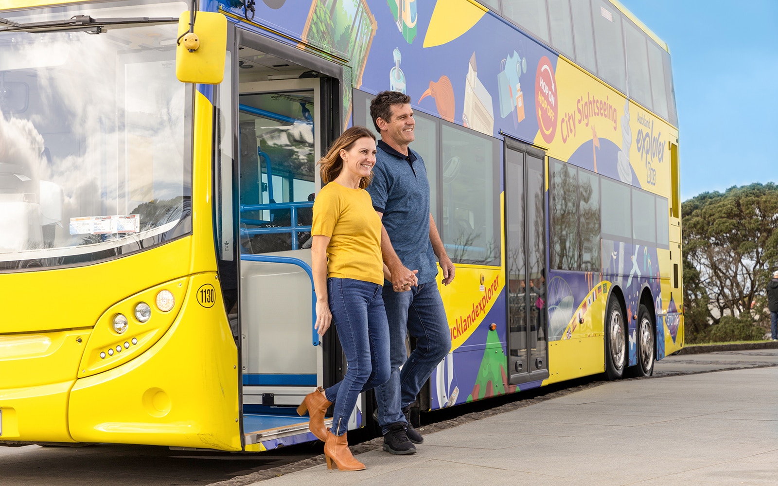 Due persone scendono da un autobus Hop-on Hop-off ad Auckland