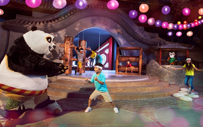 Child posing with Kung Fu Panda character Po at Kung Fu Academy, Motiongate.