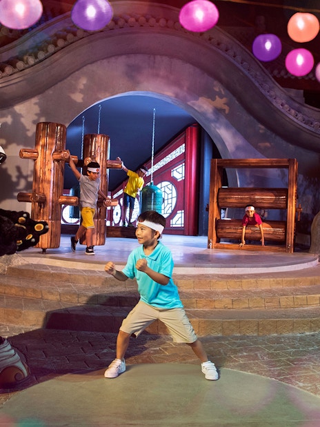 Child posing with Kung Fu Panda character Po at Kung Fu Academy, Motiongate.
