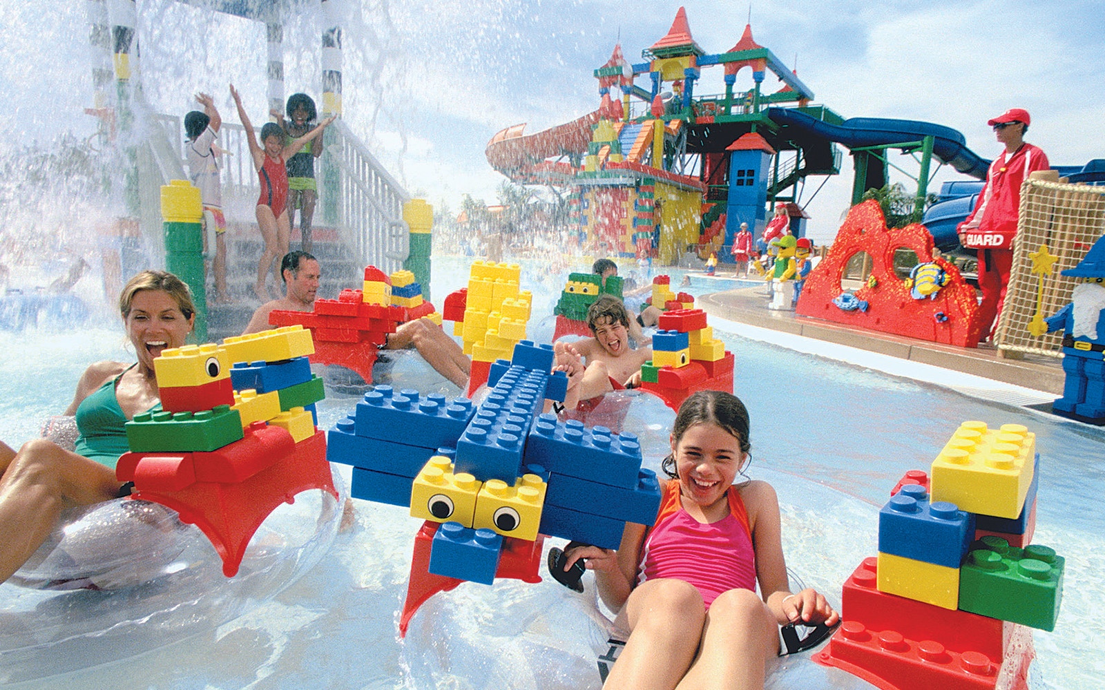 Families enjoying Build A Raft River with LEGO structures at LEGOLAND Water Park.
