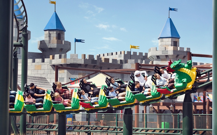 Roller coaster at Dubai Parks and Resorts with castle backdrop.