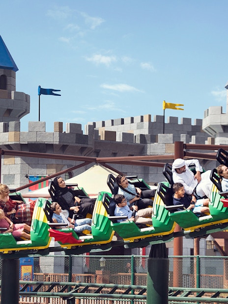 Roller coaster at Dubai Parks and Resorts with castle backdrop.