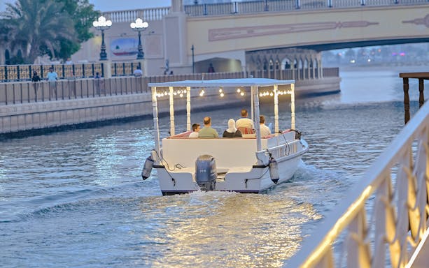 Private boat tour on Khalid Lagoon with passengers enjoying the evening view.
