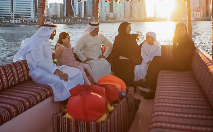 Group enjoying a private boat tour on Khalid Lagoon at sunset.