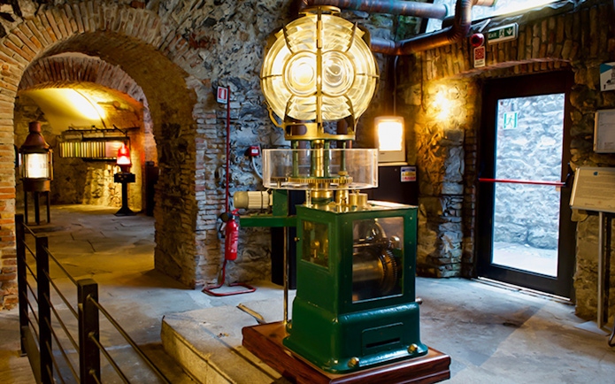 Lighthouse interior with historic lens and machinery, Genoa.