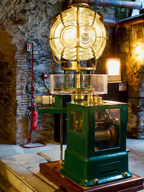 Lighthouse interior with historic lens and machinery, Genoa.