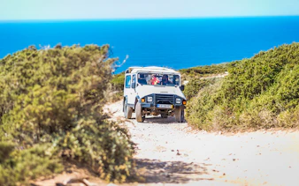Jeep driving on a coastal trail during a guided safari tour in Sintra, Portugal.