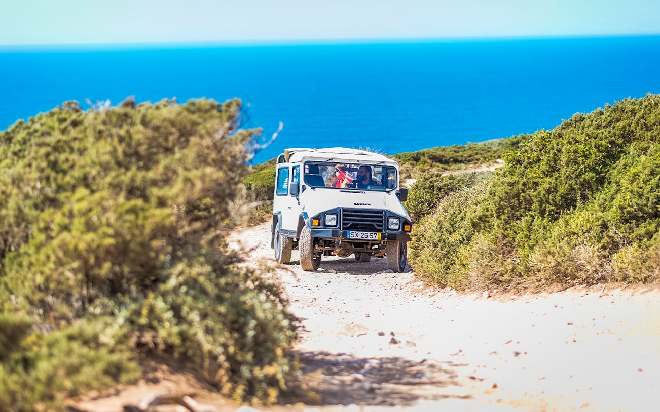 Jeep driving on a coastal trail during a guided safari tour in Sintra, Portugal.