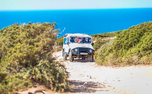 Jeep driving on a coastal trail during a guided safari tour in Sintra, Portugal.