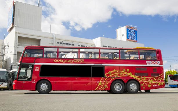 Open-top double-decker bus for Osaka Sky Vista tour parked in urban setting.