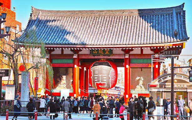 Senso-ji Temple entrance with large red lantern in Asakusa, Tokyo, bustling with visitors.