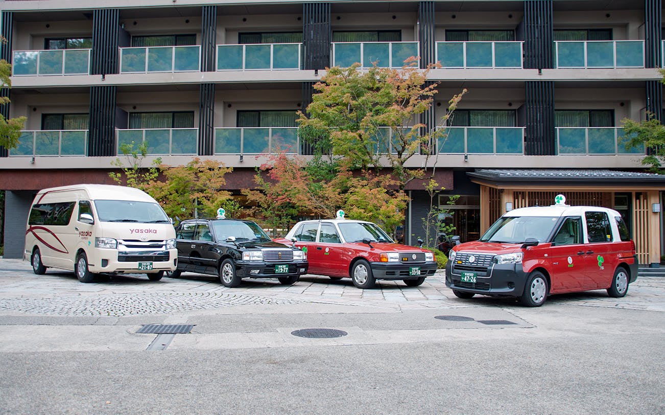 Kyoto taxis parked in front of a modern building, ready for a 2-hour sightseeing tour.