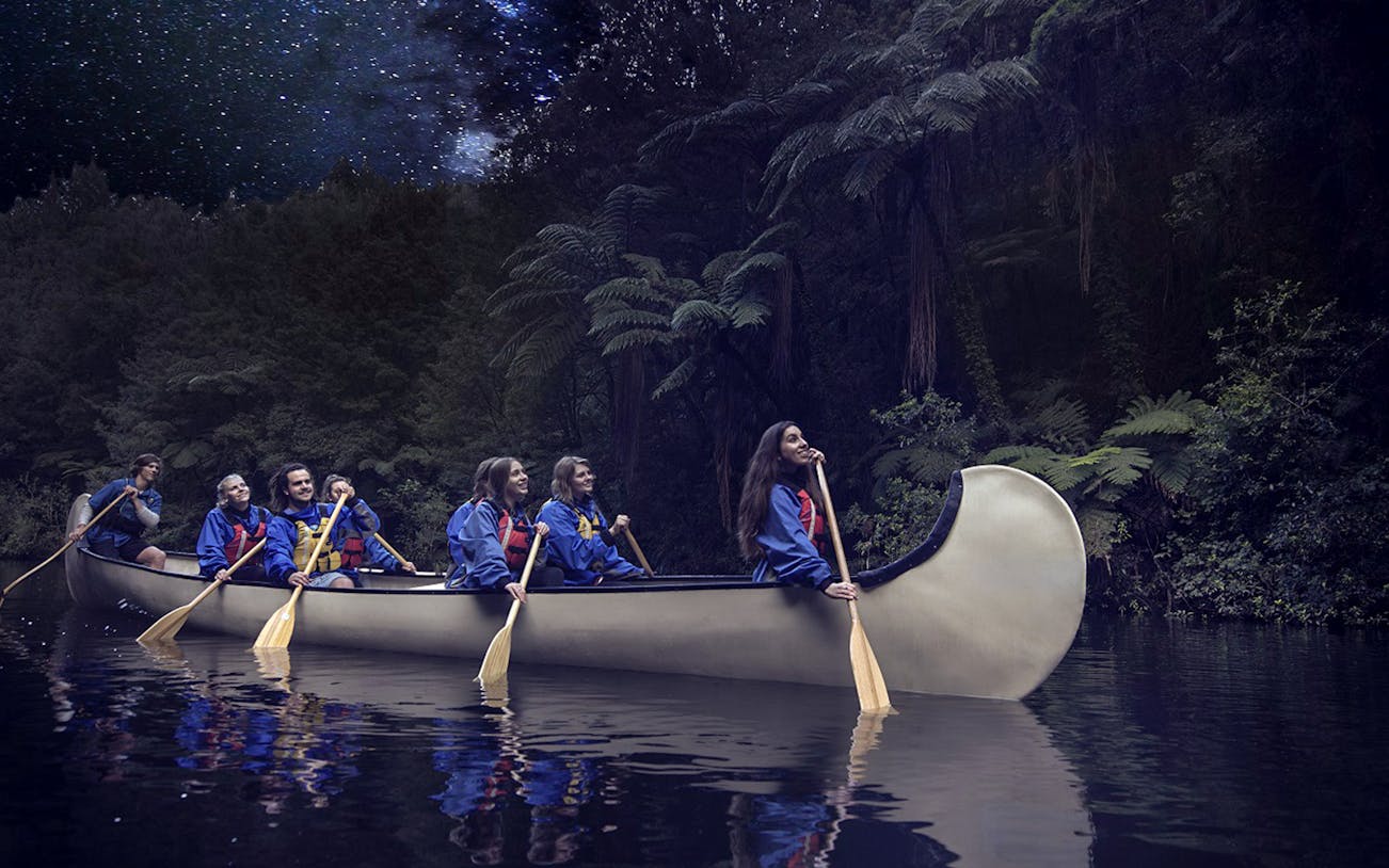 Canoe group paddling under starry sky on Big Kanu Glowworm tour from Tauranga.