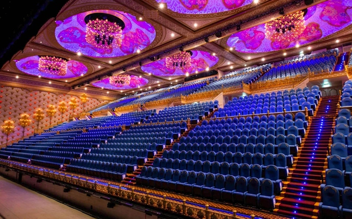 Grand theater seating at Carnival Magic Park in Phuket with ornate ceiling and chandeliers.