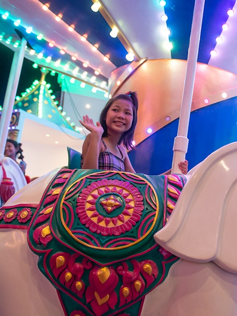 Child riding elephant carousel at Carnival Magic Park, Phuket.
