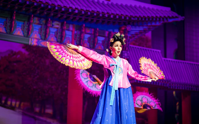 Performer in traditional costume with fans at Alcazar Cabaret Show.