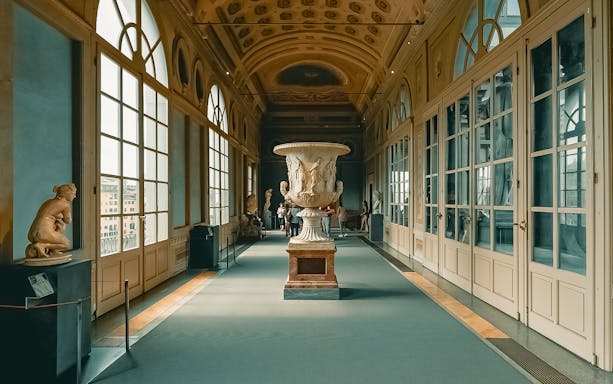 Uffizi Gallery interior with sculptures and large decorative vase, Florence.