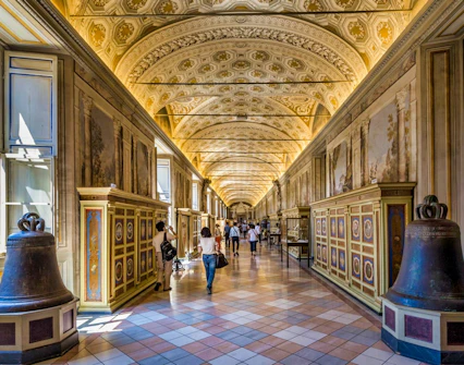 Vatican Museums ornate hallway with visitors, part of guided tour in Rome.