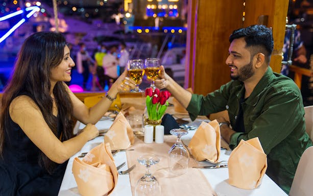 Couple toasting on a Dhow Dinner Cruise on Dubai Creek.