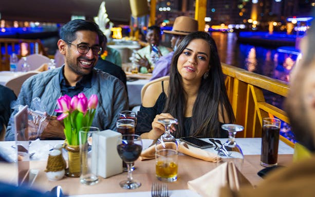 Guests dining on a Dhow Dinner Cruise on Dubai Creek.