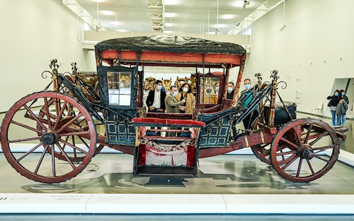 Visitors viewing a historic coach at the National Coach Museum.