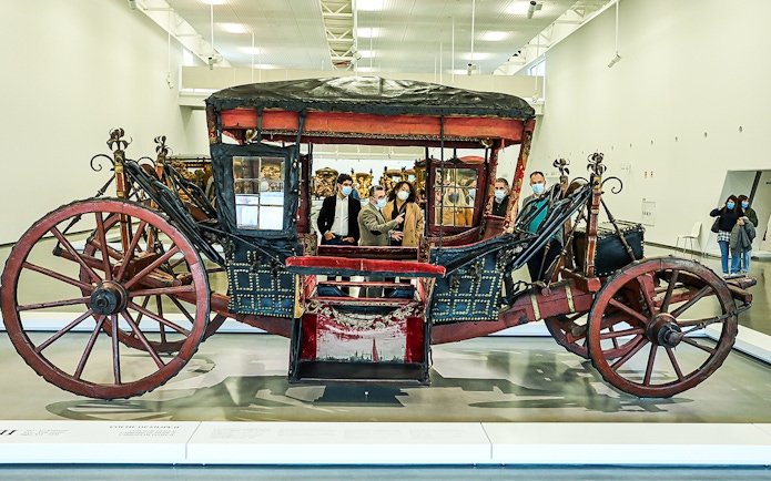 Visitors viewing a historic coach at the National Coach Museum.