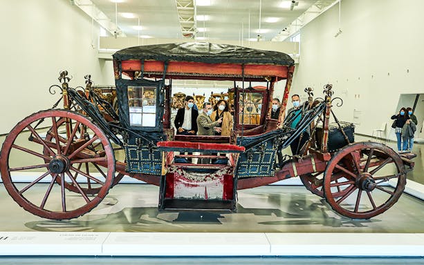 Visitors viewing a historic coach at the National Coach Museum.