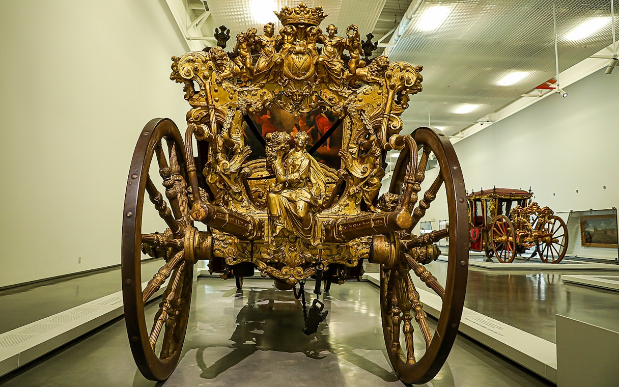 Ornate golden carriage on display at the National Coach Museum in Lisbon.