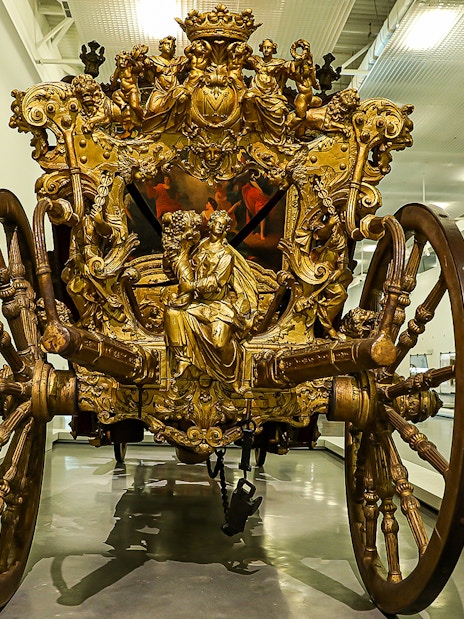 Ornate golden carriage on display at the National Coach Museum in Lisbon.