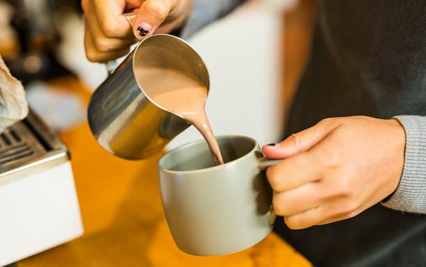 Pouring hot chocolate into a mug during a Great Ocean Road tour.