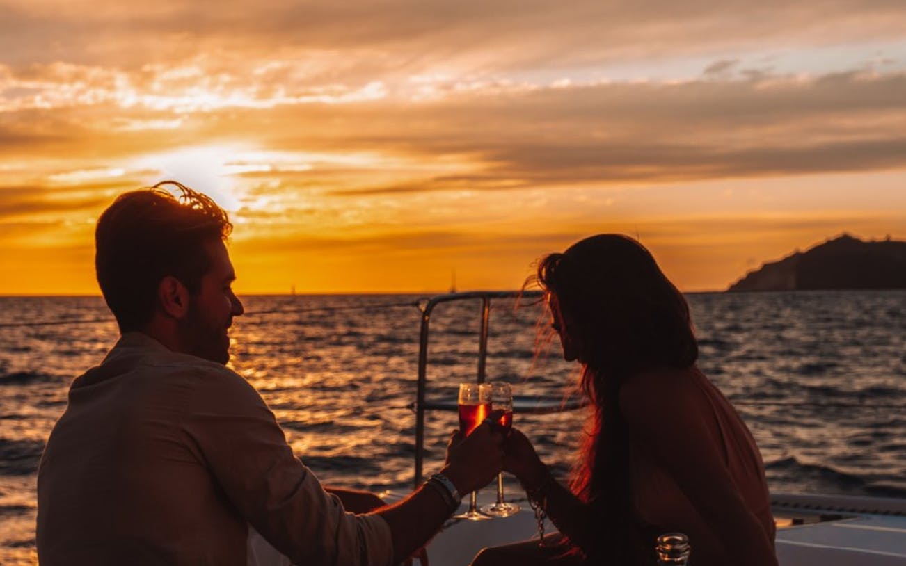 Couple toasting on a private sunset cruise with dinner.