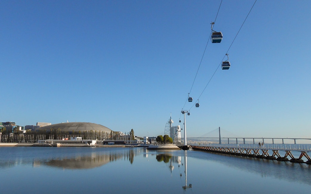 Telecabine cable car over Tagus River with Lisbon skyline in the background.