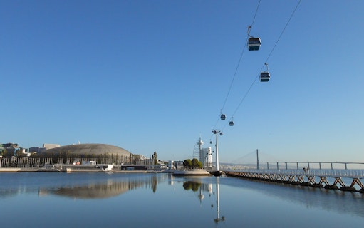 Telecabine cable car over Tagus River with Lisbon skyline in the background.