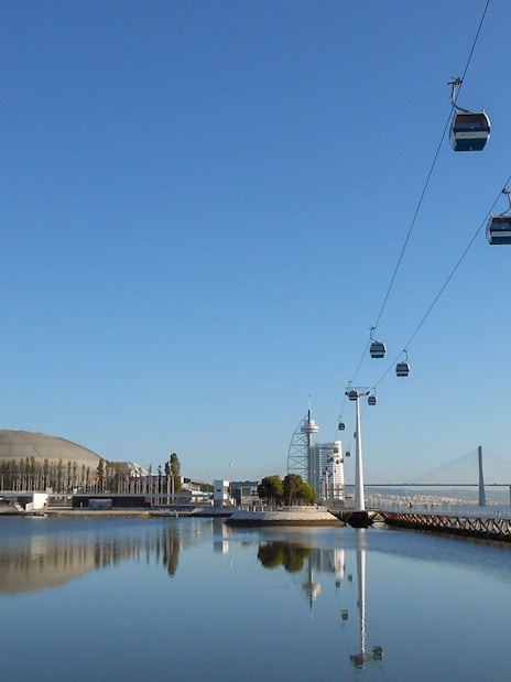 Telecabine cable car over Tagus River with Lisbon skyline in the background.
