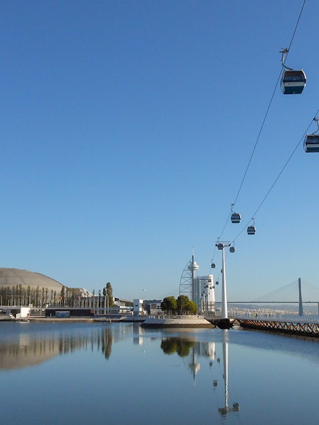 Telecabine cable car over Tagus River with Lisbon skyline in the background.