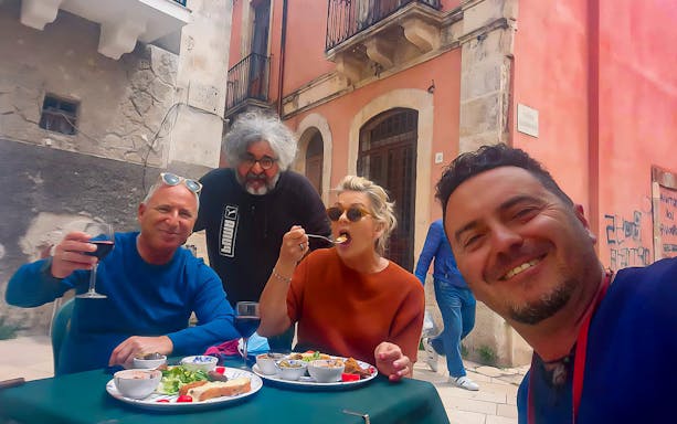 Group enjoying street food at an outdoor cafe in Syracuse.