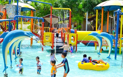 Children playing in a colorful water playground at A'Famosa Water Theme Park, Malaysia.
