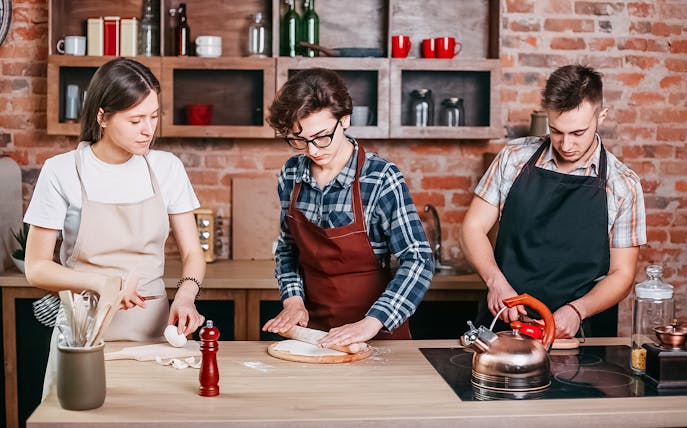 People making pizza dough in a Naples cooking class.