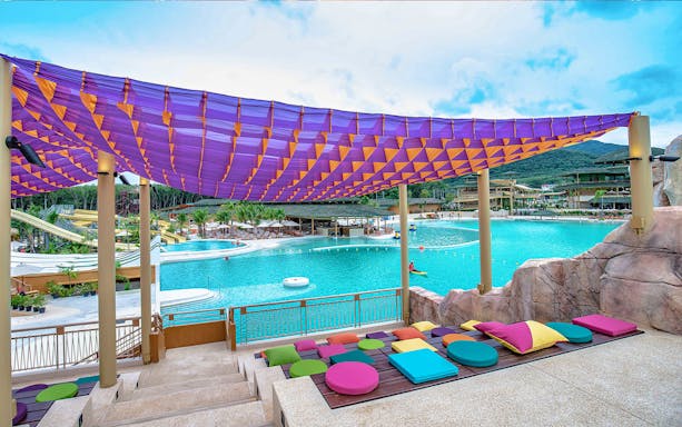 Blue Tree Water Park pool area with colorful seating and canopy in Thailand.